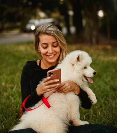 Dog owner using a phone with her dog